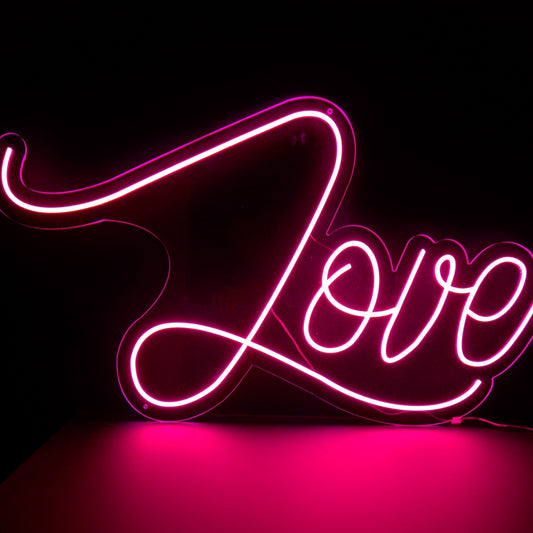a hot pink neon sign with the word love in a beautiful script font