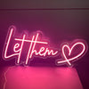 &quot;Let them&quot; quote with a heart symbol sof pink neon sign