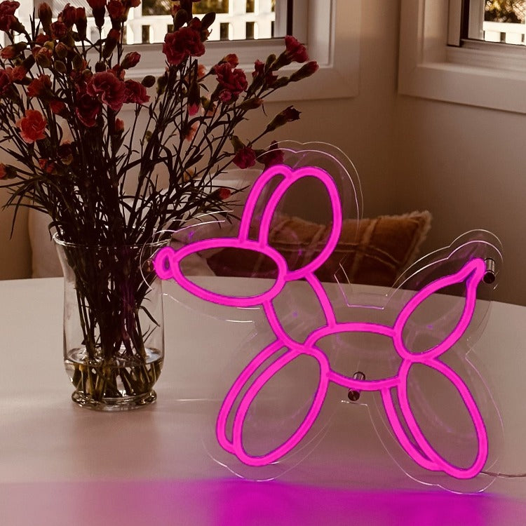 pop-art-style-balloon-dog-purple-neon-light-standing-on-a-table-infront-of-a-vase-of-purple-flowers