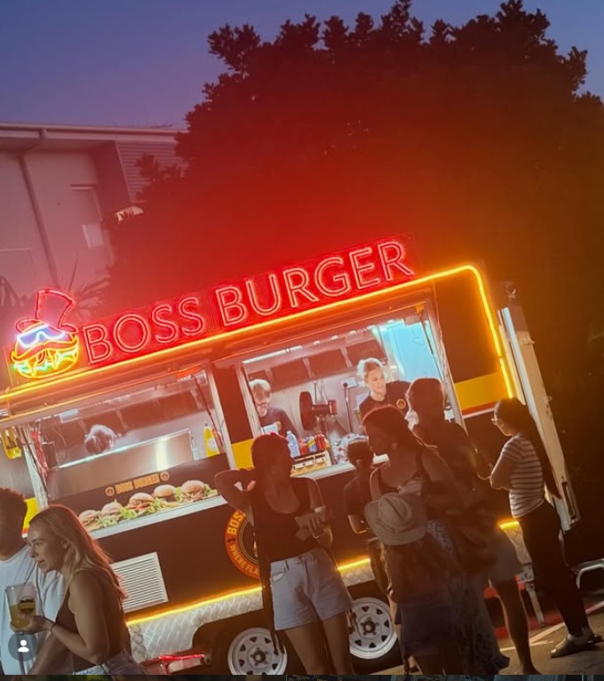 Boss Burger LED neon sign lighting up a food truck at the markets