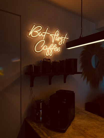 but first coffee neon sign with a warm white light glowing in the evening