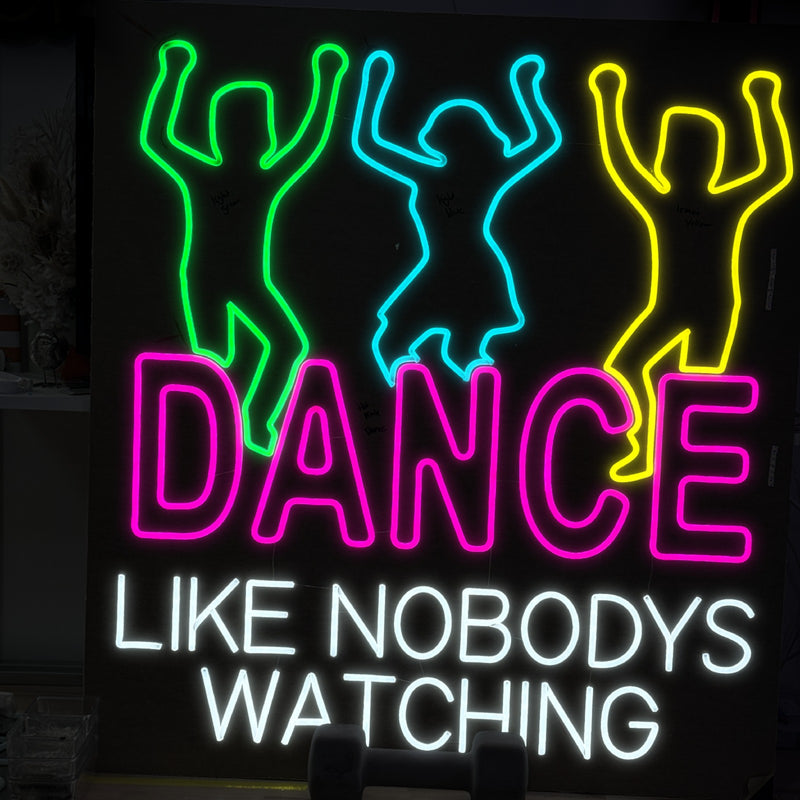 Dance Like Nobody's Watching neon sign with three dancing figures in green, aqua and yellow