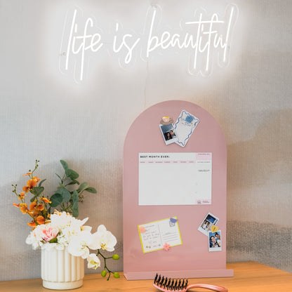 girls room neon sign above a display boatd and flowers