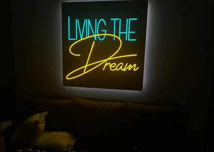 living the dream neon sign  glowing with a reflection on the glass table
