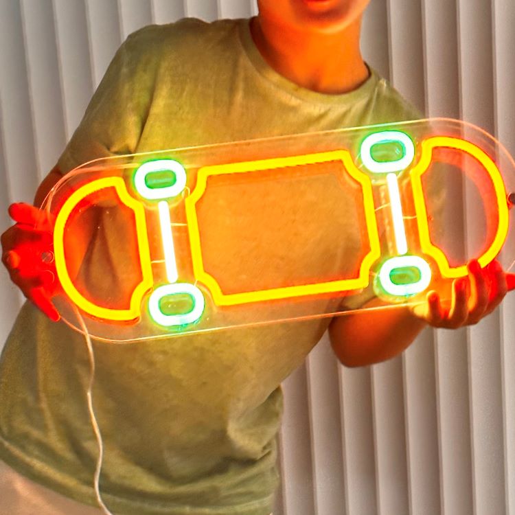 excited-boy-holding-his-new-custom-made-orange-and-green-skateboard-neon-sign