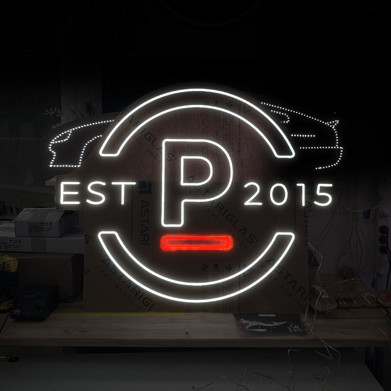 Round P logo neon sign reading Est 2015, in white with a red bar and a dotted car outline