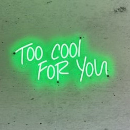 bright green neon sign "too cool for you" mounted on a concrete wall